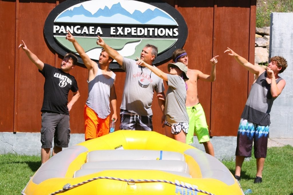 Group pointing at something in the sky next to a yellow raft