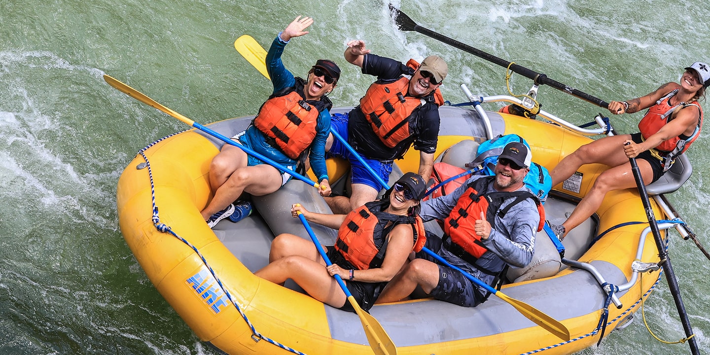 particpants wave while on a clark fork river rafting trip