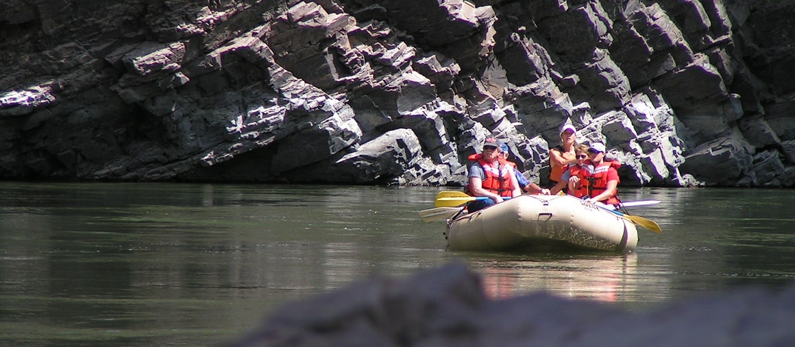 boat and cliffs on clark fork river rafting trip
